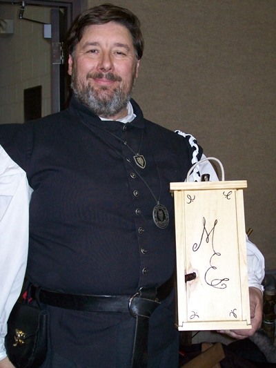 Morgan holding the box showing the lid in place with the initials M E burned in)